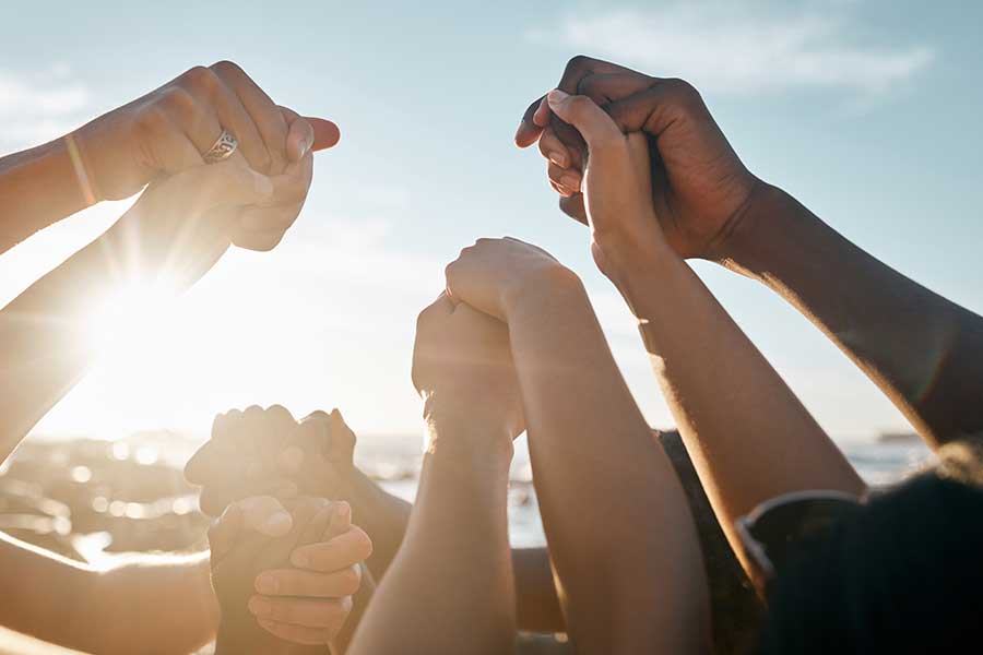 People joining hands together in unity and teamwork
